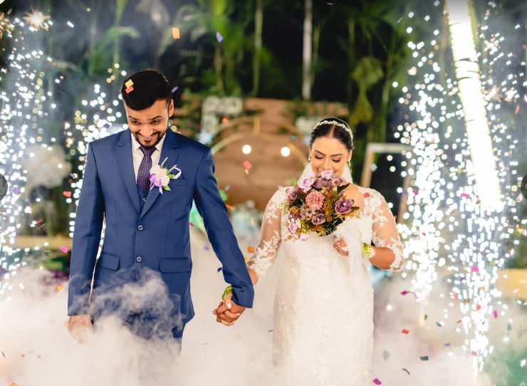 Bride and groom walking through sparklers and confetti