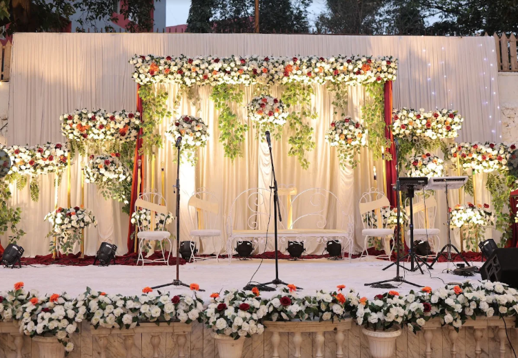 White floral photo wall lit with string lights